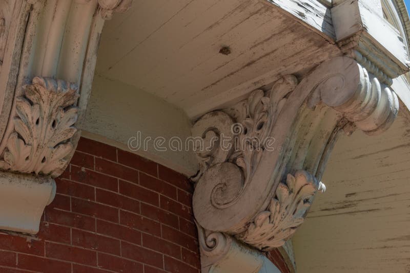 Detail of elaborate corbels beneath a curved balcony and brick wall