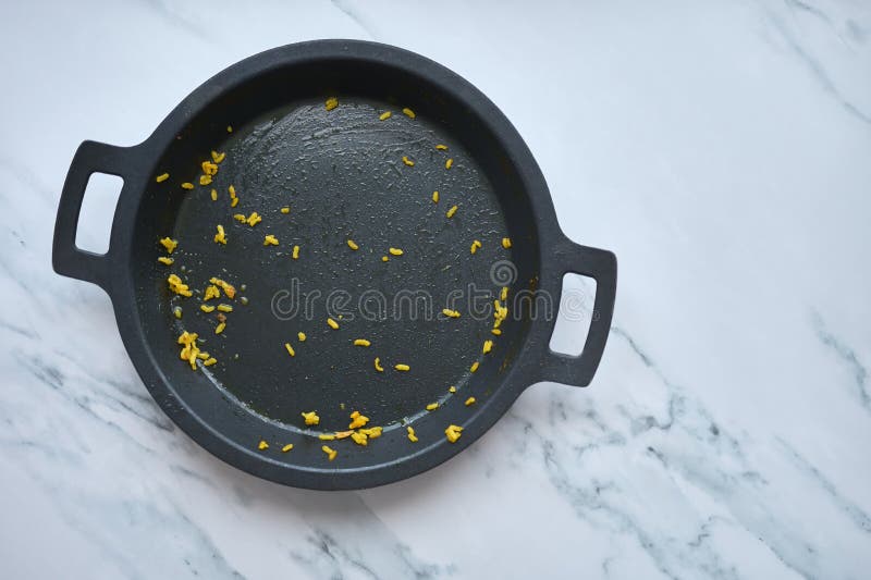 Empty Paella Pan with Leftover Rice on a White Marble Background Stock