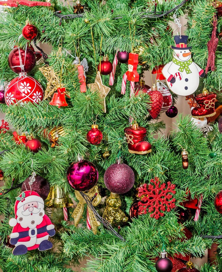 Detail of green Christmas (Chrismas) tree with colored ornaments, globes, stars, Santa Claus, Snowman