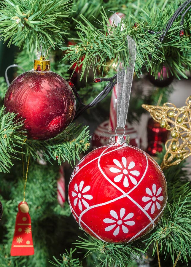 Detail of green Christmas (Chrismas) tree with colored ornaments, globes, stars, Santa Claus, Snowman