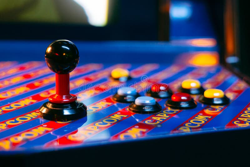 Detail on a joystick and six button controls of a blue arcade game