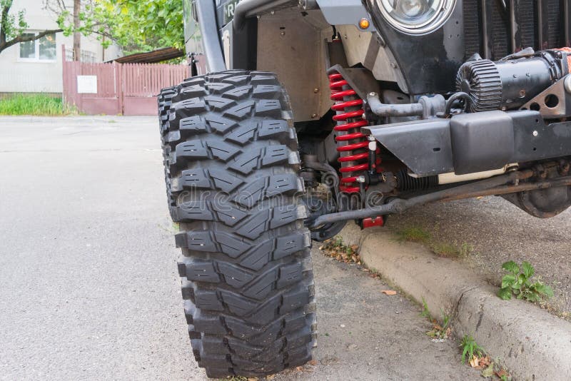 Detail of offroad vehicle showing big tire and red coil suspension stock photography Detail of offroad vehicle showing big tire and red coil suspension stock photography