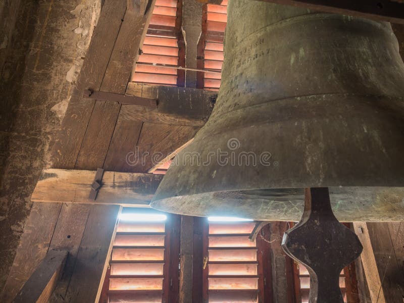 Detail of an old church bell in the red wooden belfry.