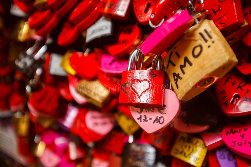 Wall full of red and pink love locks shaped as hearts and classic locks. Wall full of red and pink love locks shaped as hearts and classic locks
