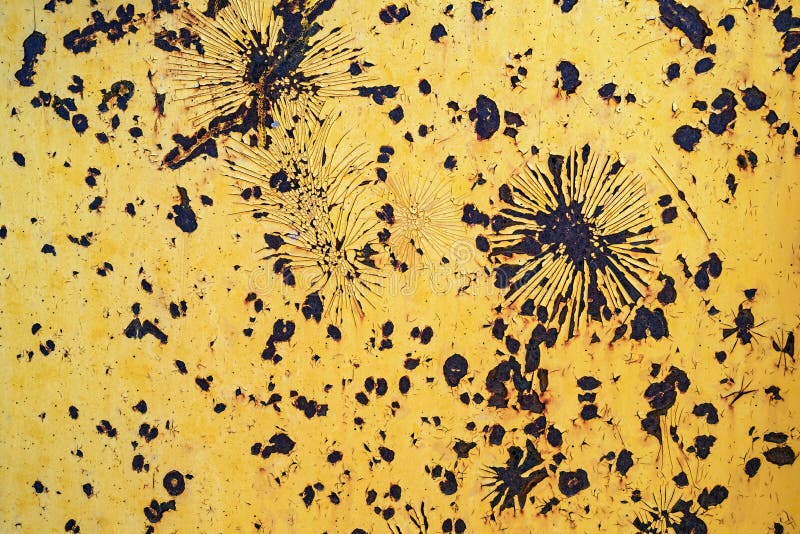 Detail of the peeling yellow paint on the rusty surface of a backhoe royalty free stock images