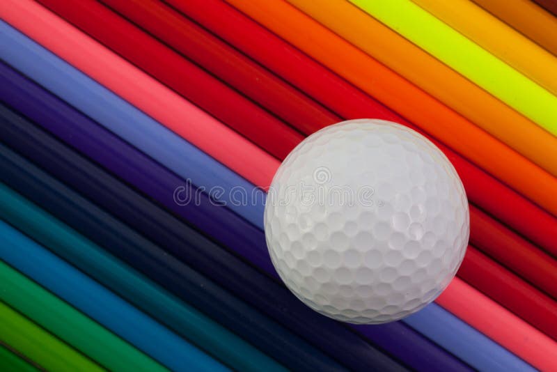 Detail of rainbow colorful pencil and golf ball on the desk