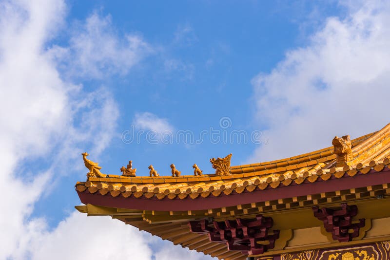 Hacienda Heights, CA, USA - March 23, 2018: Red ochre roof structure of Hsi Lai Buddhist Temple under blue-white cloudscape. Corner tip with figurine decoration. Hacienda Heights, CA, USA - March 23, 2018: Red ochre roof structure of Hsi Lai Buddhist Temple under blue-white cloudscape. Corner tip with figurine decoration.