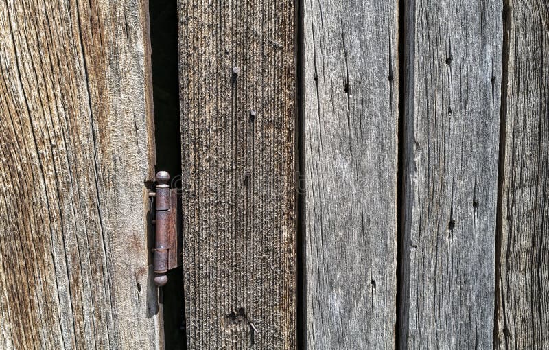 Detail of a rusty hinge on the door of an abandoned wood building royalty free stock images