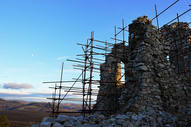 Detail of scaffolding on medieval castle tower of castle Hrusov, central Slovakia. Sunlit by evening sunshine.