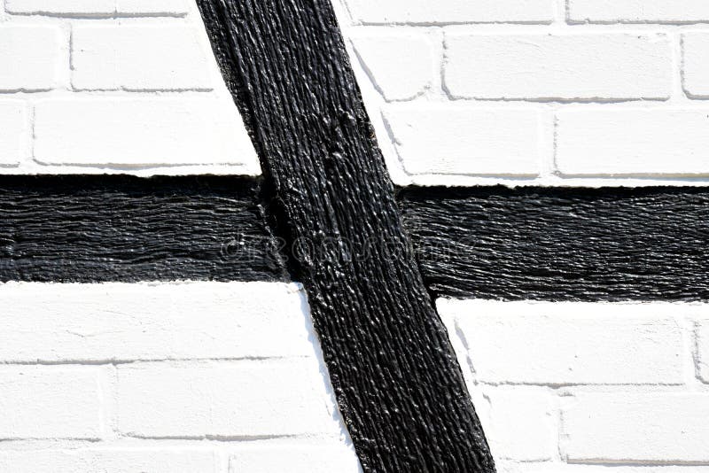 Detail of the side wall of a half-timbered house with black wooden beams and whitewashed walls of mud bricks, Germany