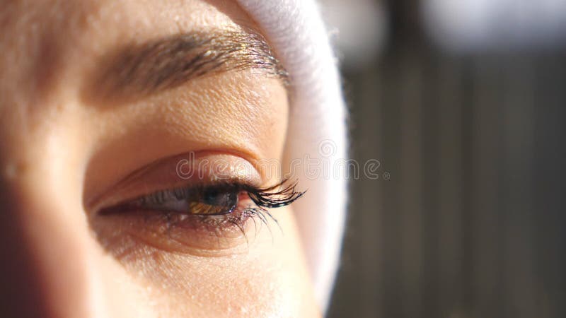 Detail view on face of woman with brown eyes admiring beautiful winter views. Attractive brown-eyed girl blinking and