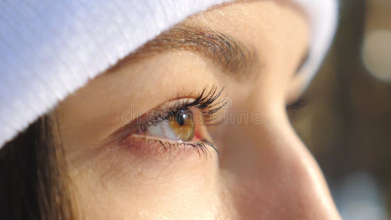 Detail view of woman face with beautiful brown eyes. Attractive girl standing in winter forest and looking around. Slow