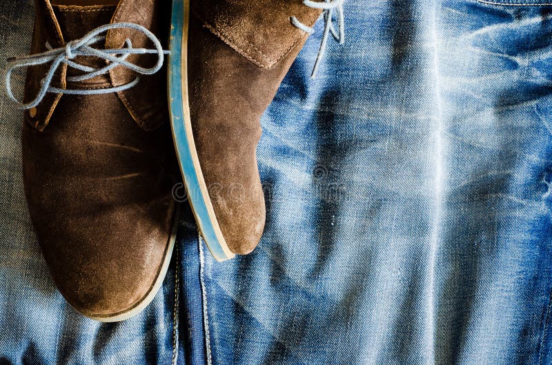 Detail of vintage leather shoes on denim fabric