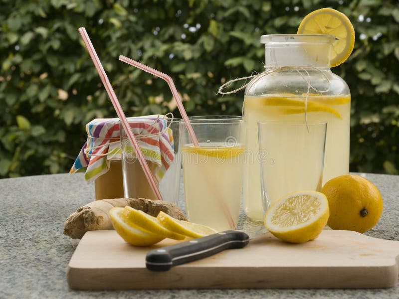 Detailed Picture of all ingredients neccesary to cook a homemade lemonade consist from water, lemon, ginger and glass of honey.