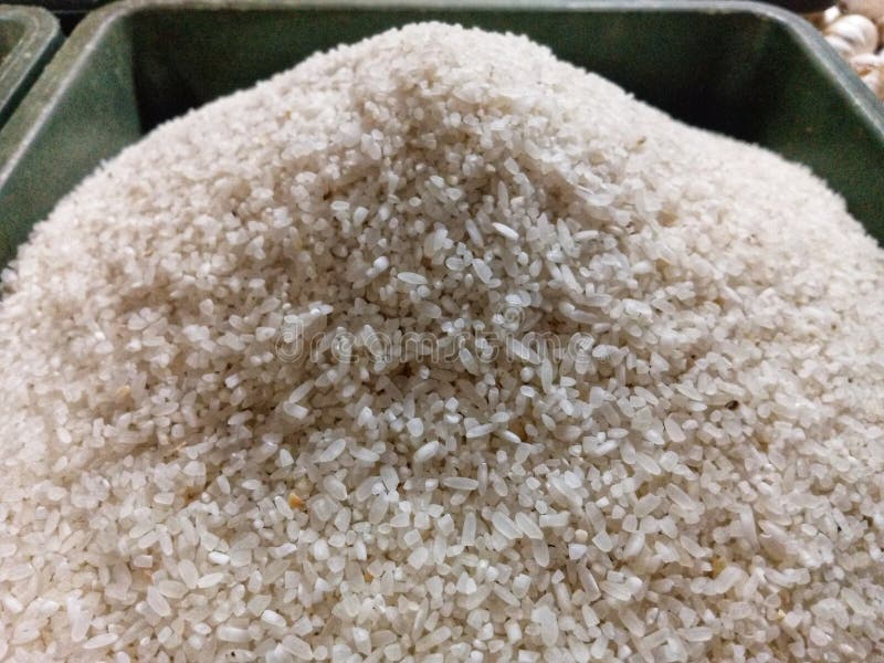 A detailed shot of a large mound of white rice grains, likely broken rice, in a container stock image