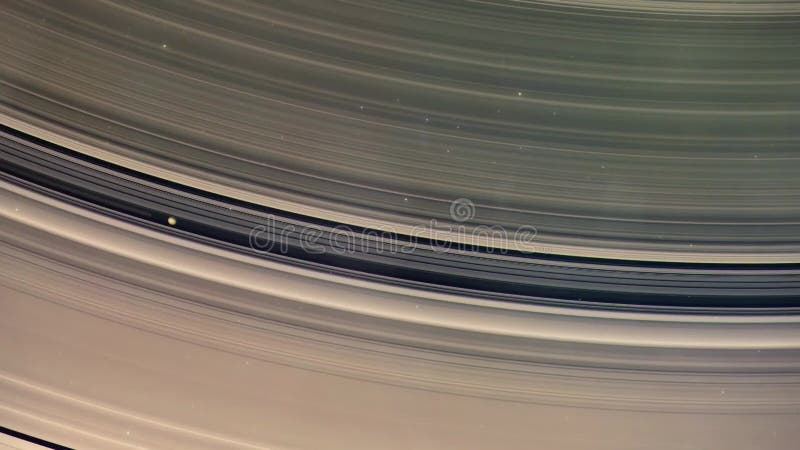 A detailed view of Saturn\'s magnificent rings with an orbiting moon. royalty free illustration