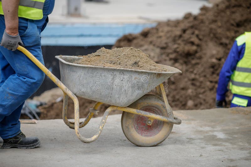 Details with a Construction Worker Pushing a Wheelbarrow on a