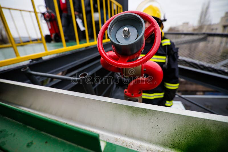 Details with the Hands of a Firefighter Holding a Fire Suppression