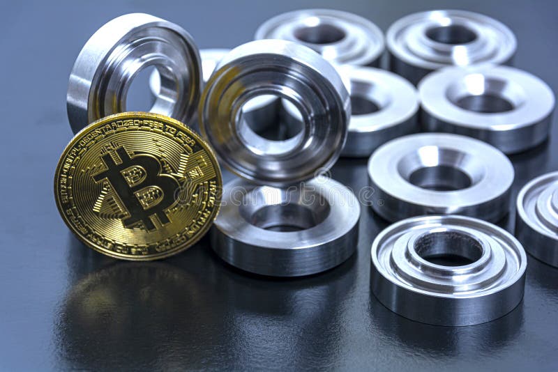 Details machined on a lathe and bitcoin on a black background. The concept of real and virtual income, earnings on the Internet stock photo