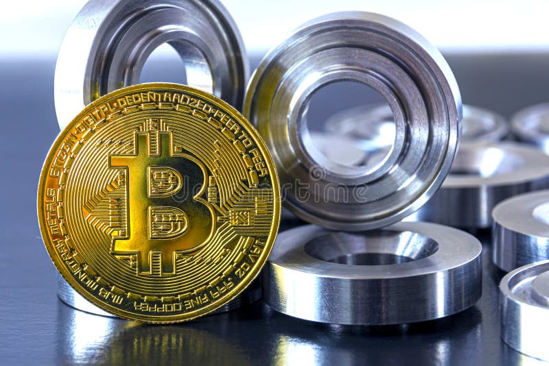 Details machined on a lathe and bitcoin on a black background. The concept of real and virtual income, earnings on the Internet stock images