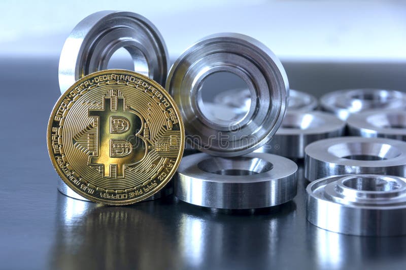 Details machined on a lathe and bitcoin on a black background. The concept of real and virtual income, earnings on the Internet royalty free stock image