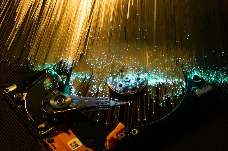 Details of opened computer hard disk drive with colored optic fiber effects stock photo