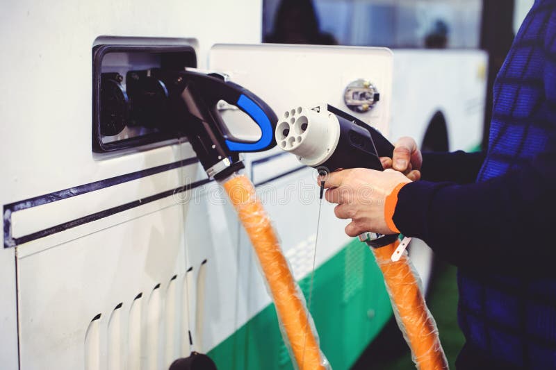 Details stadt-Bustransportes des Elektro-Mobils des Aufladungs Grün und erneuerbare Energiequellen Manngriffe in seiner Hand stockfotos Details stadt-Bustransportes des Elektro-Mobils des Aufladungs Grün und erneuerbare Energiequellen Manngriffe in seiner Hand stockfotos