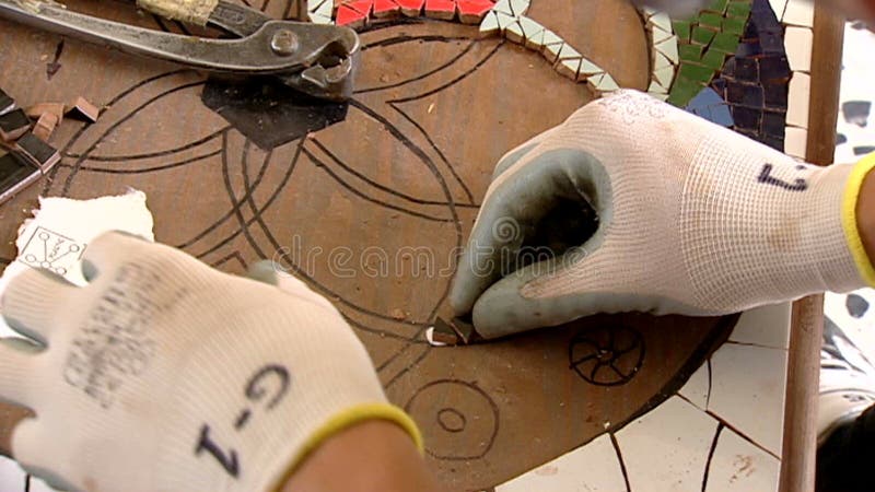 Details van kunstenaarshanden wanneer het werken met mozaïek