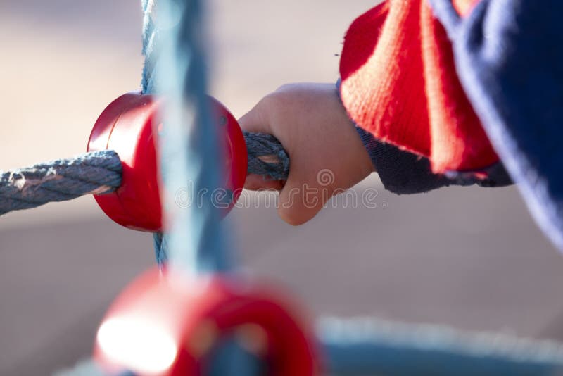Detalhe da mão de um menino da criança de dois anos que joga em um parque exterior em um dia de inverno ensolarado fotos de stock Detalhe da mão de um menino da criança de dois anos que joga em um parque exterior em um dia de inverno ensolarado fotos de stock