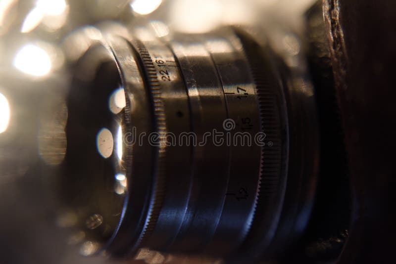 Detail of vintage photo camera. close up photo of old camera lens on beautiful bokeh. image is retro filtered. selective focus. Detail of vintage photo camera. close up photo of old camera lens on beautiful bokeh. image is retro filtered. selective focus