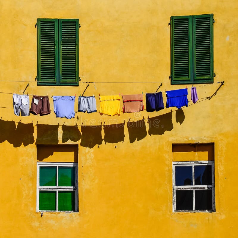 Detalhe de paredes, de janelas e de roupa amarelas coloridas da casa fotografia de stock royalty free Detalhe de paredes, de janelas e de roupa amarelas coloridas da casa fotografia de stock royalty free