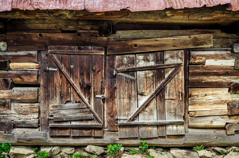 Detalj av den gamla trätexturerade och red ut ladugårddörren arkivbilder Detalj av den gamla trätexturerade och red ut ladugårddörren arkivbilder