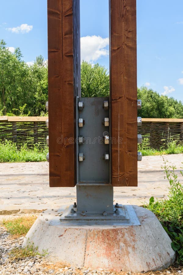 Detaljen av den massiva wood stolpen som ankrades med det speciala metallkontaktdonet genom att använda muttrar - och - bultar ti royaltyfria foton Detaljen av den massiva wood stolpen som ankrades med det speciala metallkontaktdonet genom att använda muttrar - och - bultar ti royaltyfria foton