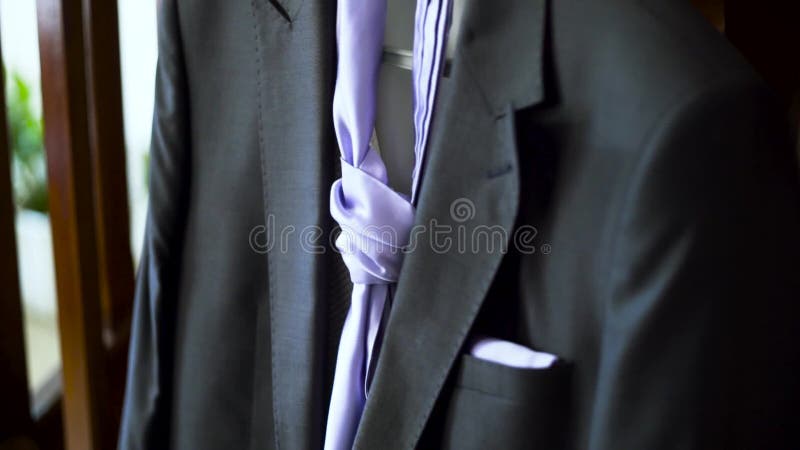 Detalle de la boda traje negro masculino con corbata púrpura preparado para el novio Acción Elegante traje de hombre oscuro con