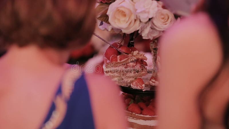 Detalle del corte del pastel de bodas por el pastel de bodas de los recienes casados