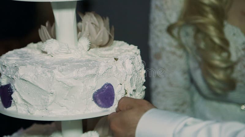 Detalle del corte del pastel de bodas por el pastel de bodas de los recienes casados