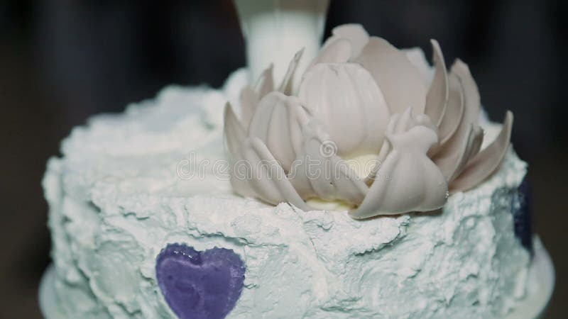 Detalle del corte del pastel de bodas por el pastel de bodas de los recienes casados