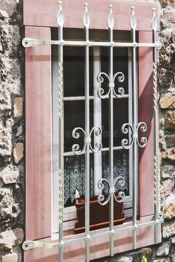 Detalles de la decoración y del interior Una ventana falsa con una parrilla decorativa del metal en la fachada del edificio contr imagen de archivo libre de regalías Detalles de la decoración y del interior Una ventana falsa con una parrilla decorativa del metal en la fachada del edificio contr imagen de archivo libre de regalías