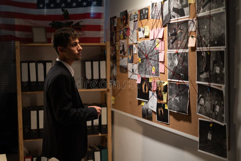 Detective Looking on Investigation Board with Photos of Suspected