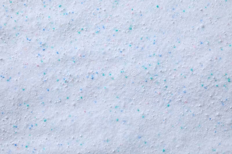 Detergente de polvo para lavado con granulado de color como fondo