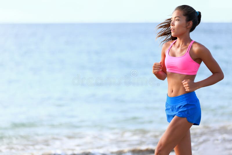 Determined woman jogging on beach. Fit young female is in sports clothing. Jogger is exercising against ocean during sunny day. Determined jogger stock images, royalty-free photos and pictures