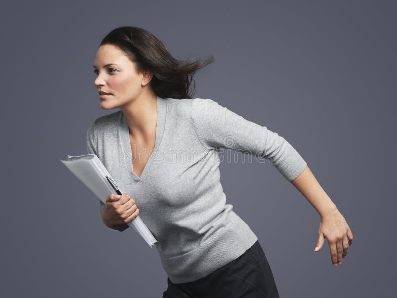 Determined Young Businesswoman Running Into Wind royalty free stock image
