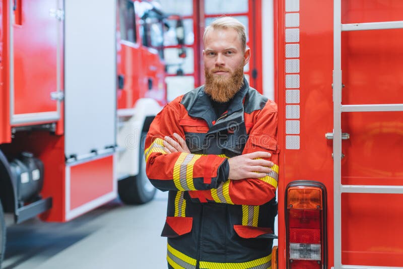 Determined young fire fighter in front of a fire truck royalty free stock photo