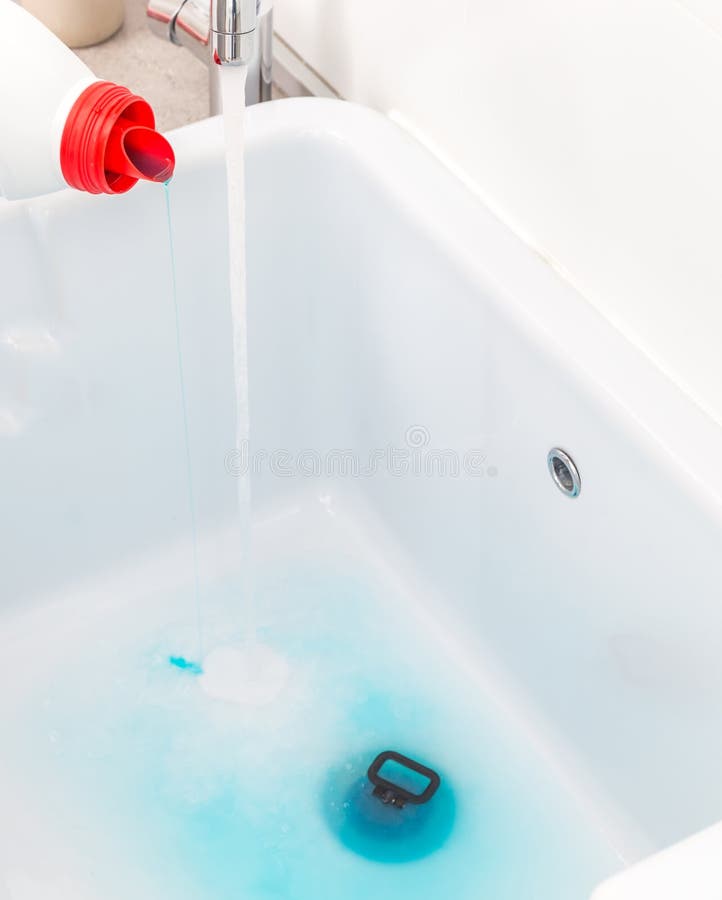 Detersivo blu di versamento nel lavandino vuoto prima di lavare i vestiti nella stanza di lavanderia fotografia stock Detersivo blu di versamento nel lavandino vuoto prima di lavare i vestiti nella stanza di lavanderia fotografia stock
