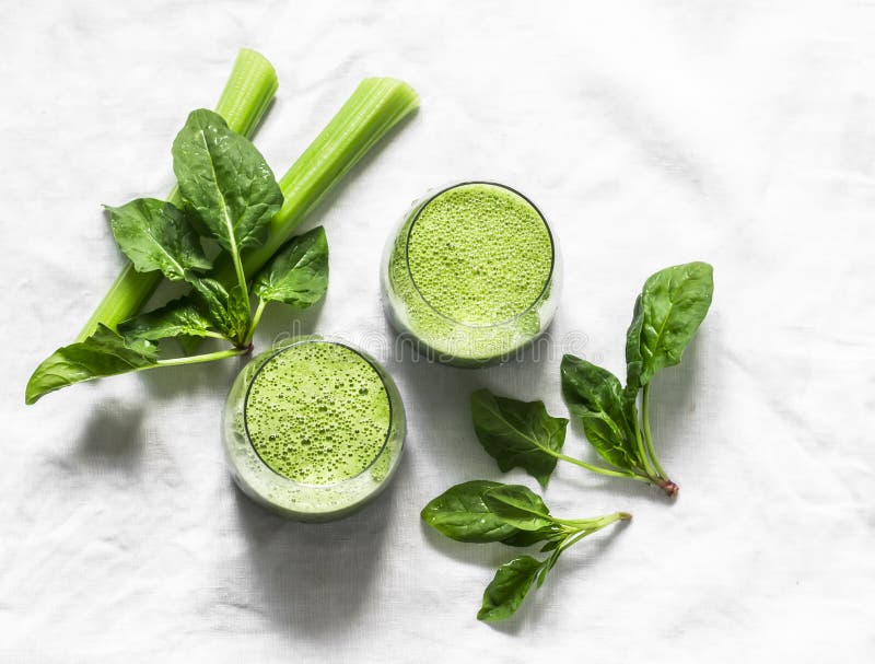 Detox diet food vegetarian concept.  Freshness celery, spinach, natural orange juice green smoothies on a light background, top