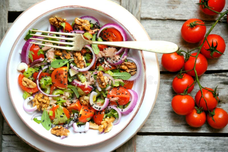 Detox, vegan, ακατέργαστη σαλάτα με τις ντομάτες, τα κρεμμύδια και τα ξύλα καρυδιάς στοκ φωτογραφία με δικαίωμα ελεύθερης χρήσης