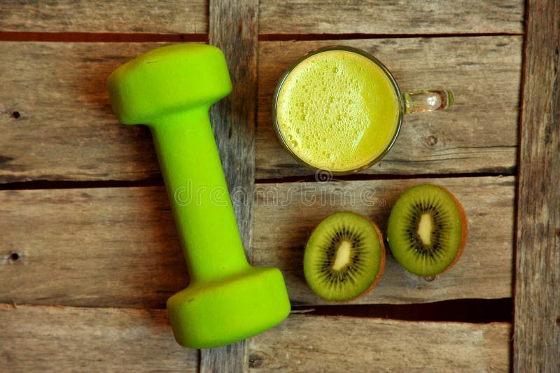 Detoxmat med kiwismootie och en grön lyftande vikt royaltyfri foto Detoxmat med kiwismootie och en grön lyftande vikt royaltyfri foto