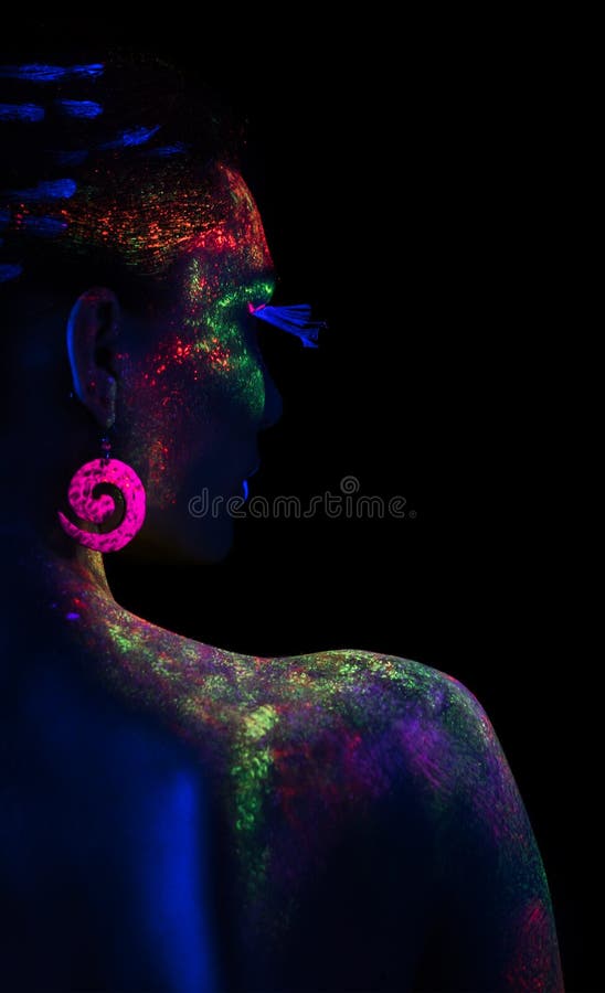 Cara de mujer en la oscuridad con pintura fluorescente maquillaje  sosteniendo un velo blanco bajo las luces negras deep blue Fotografía de  stock - Alamy