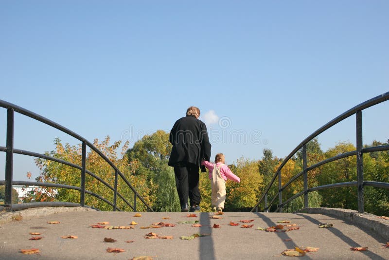 Behind grandmother and baby on autumn bridge. Behind grandmother and baby on autumn bridge