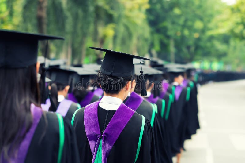 Detrás de graduados durante el comienzo en la universidad Ciérrese para arriba en imagen de archivo libre de regalías Detrás de graduados durante el comienzo en la universidad Ciérrese para arriba en imagen de archivo libre de regalías